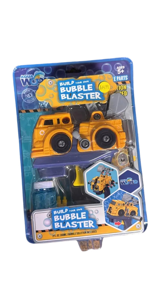 A toy construction vehicle set in retail blister packaging, labeled 'Build Your Own Bubble Blaster,' photographed on a textured carpet background. The package contains a yellow and blue bubble blaster toy with accessories.